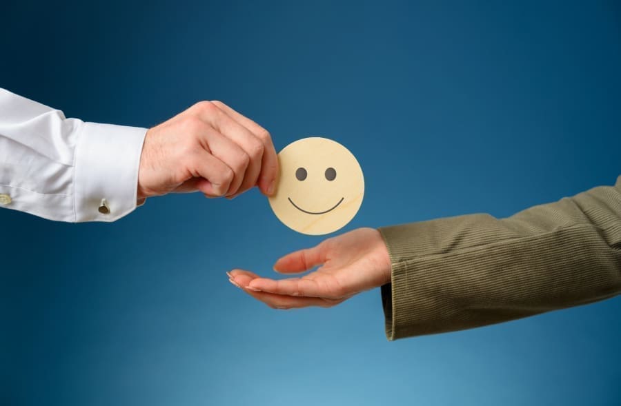 a person passing a smiley face to another person