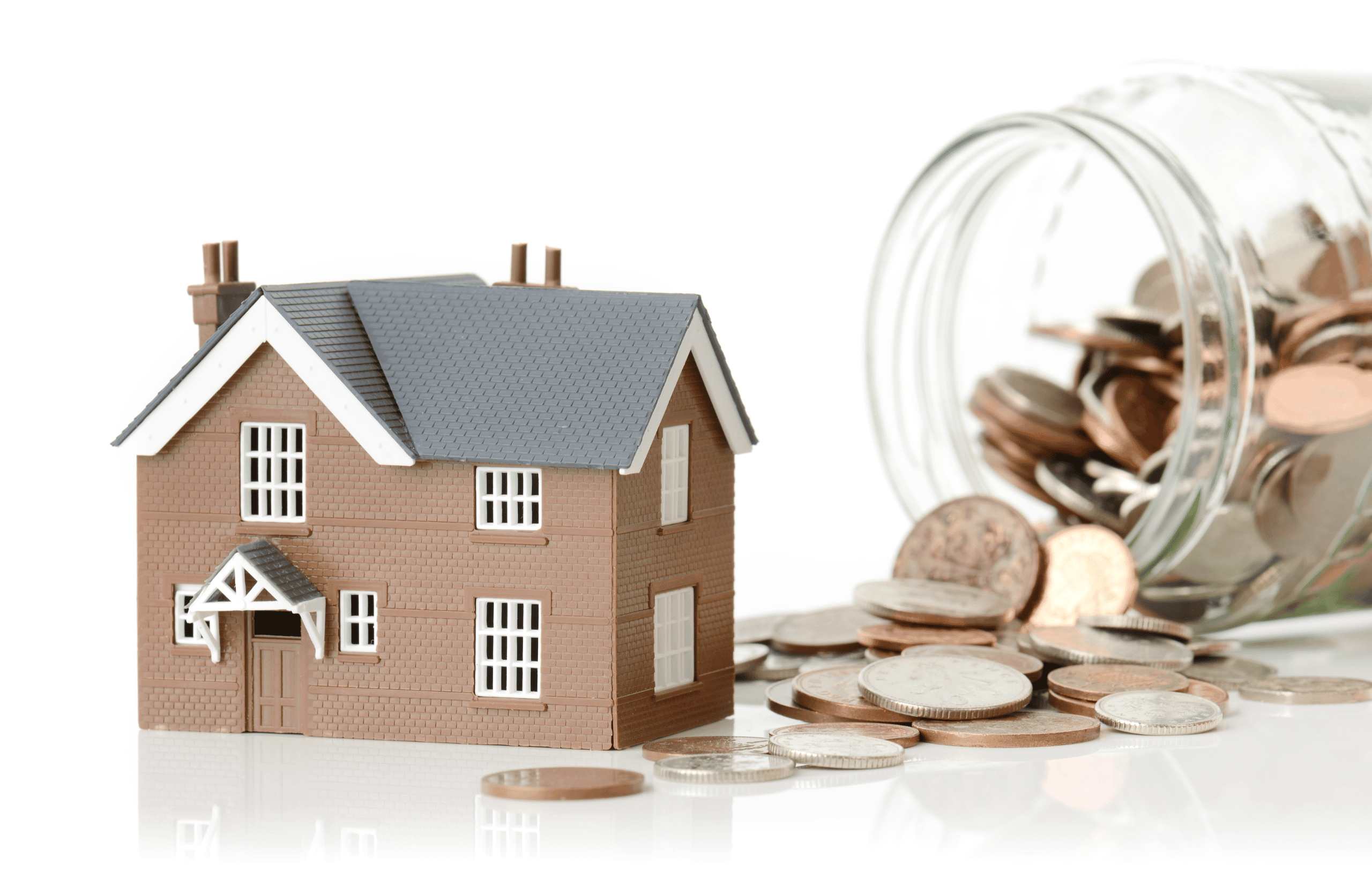 small model house next to a spilt jar of pennies